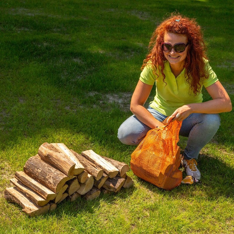 Milda si bere dříví potřebné pro ohřev vody ve svém koupacím sudu.